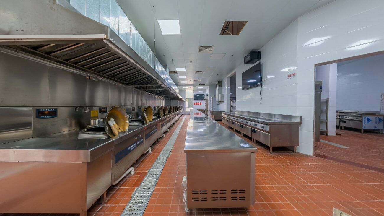 Cuisine de restaurant classique avec équipements inox autour du poste plonge