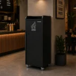 Poubelle snack bois noir 100 L installée en salle de restauration rapide près du comptoir