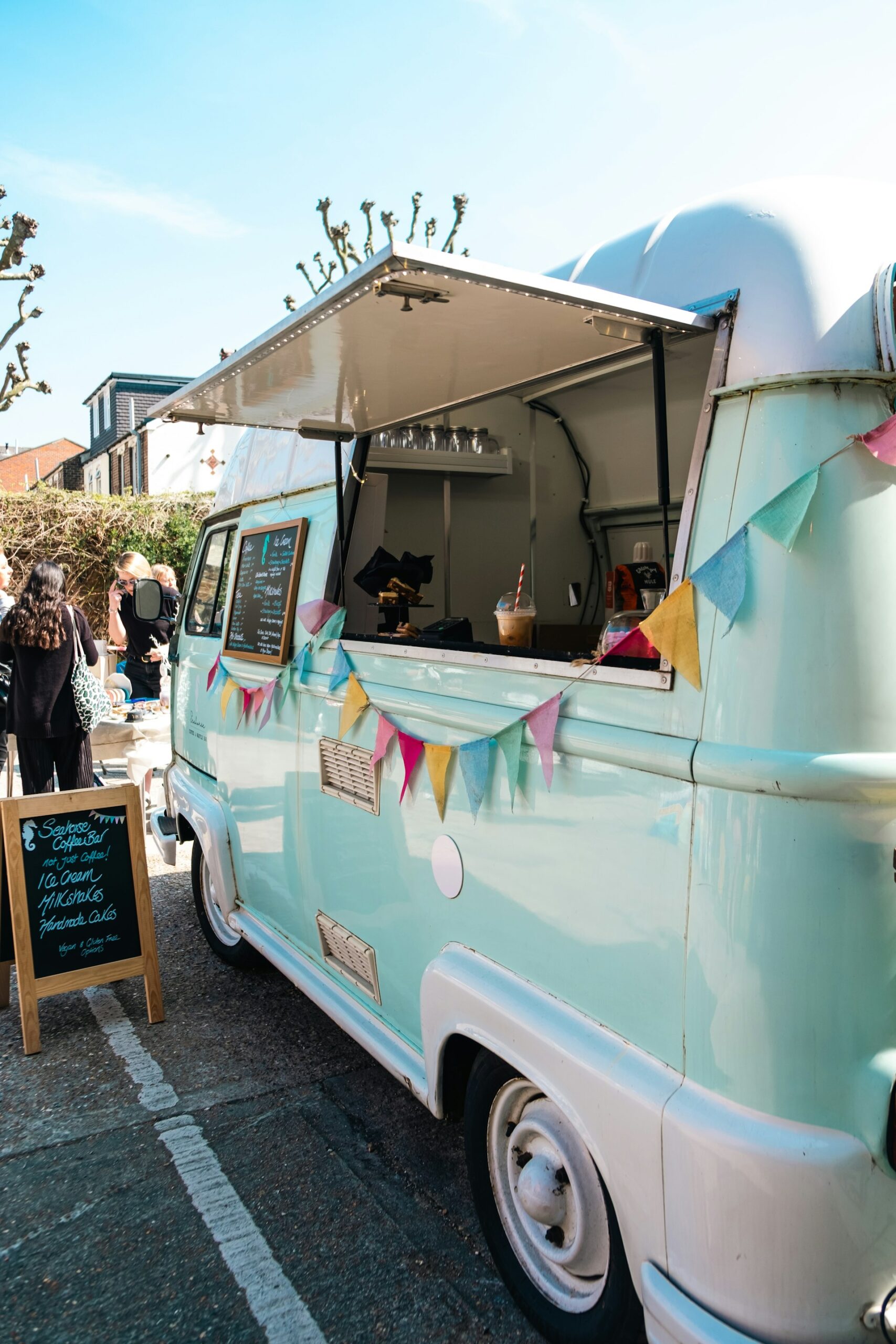 Camion bleu et blanc aménagé en food truck, hayon ouvert