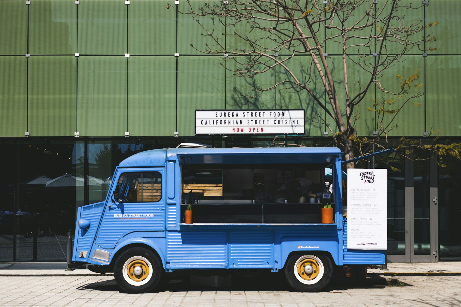 Ancien fourgon bleu aménagé en food truck, garé en ville