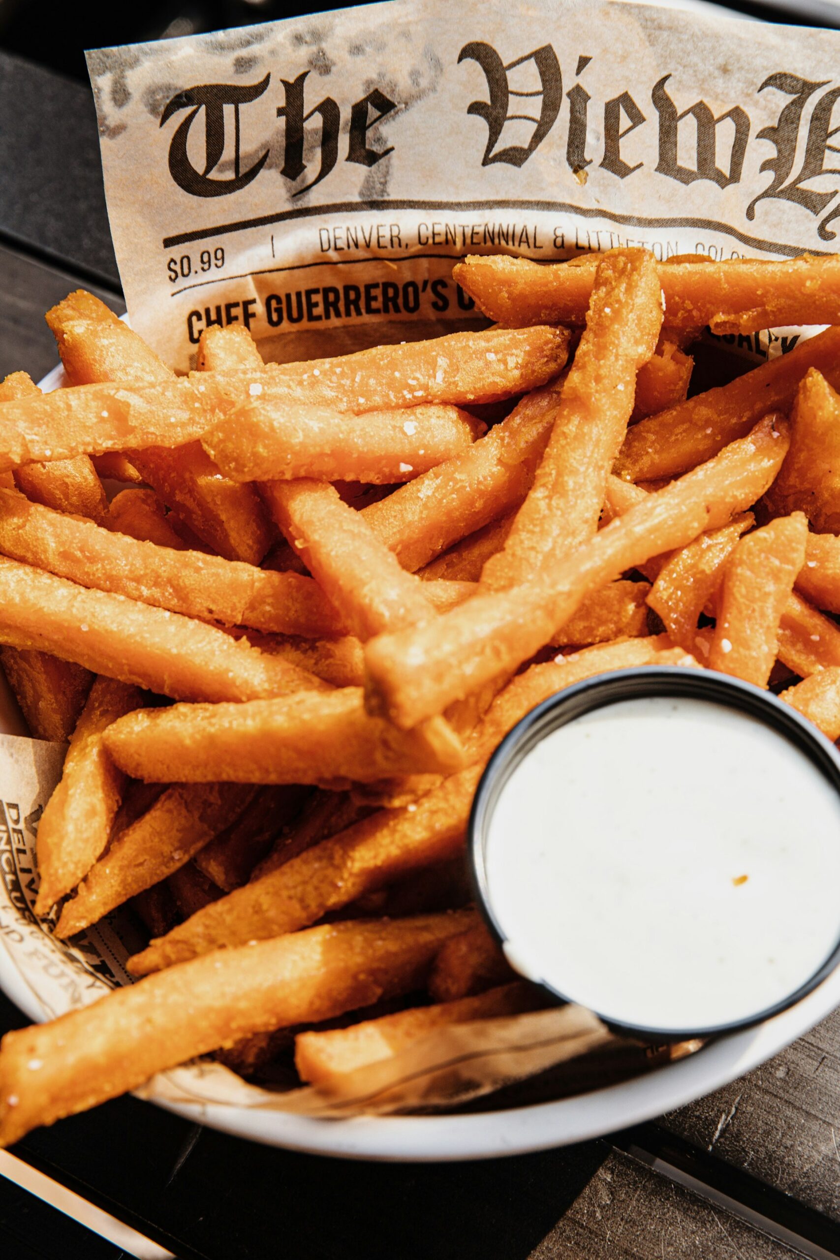 Frites servies sur du papier avec une sauce
