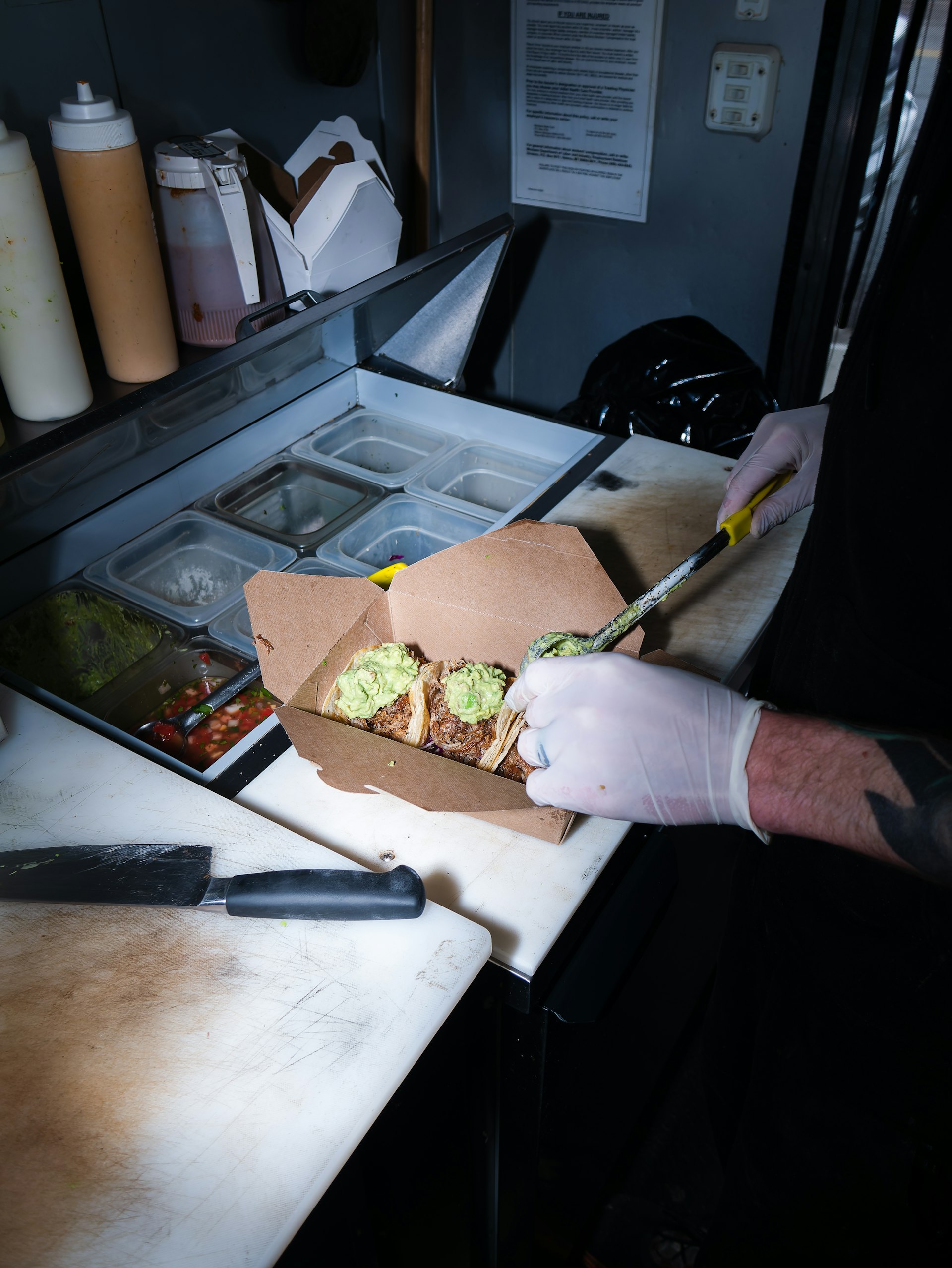Préparation de tacos avec des gants dans un food truck