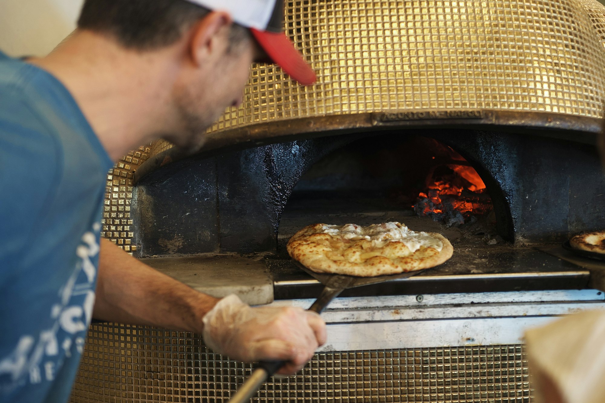 Pizzaiolo enfournant une pizza dans le four